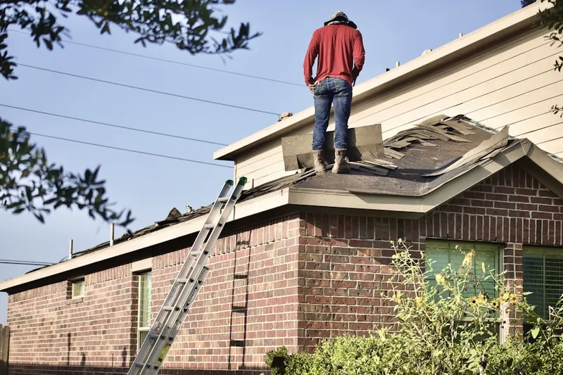 Professional roofer working on a residential roof in Sandpiper